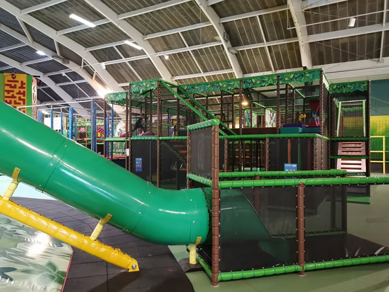 Gezinsvriendelijk indoor speeltuin met glijbanen Veilig indoor speelparadijs met glijbanen en klimrekken voor kinderen.